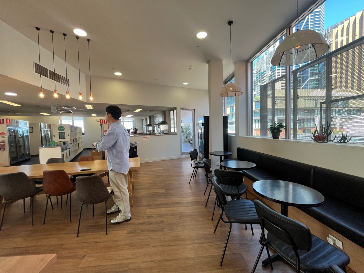 From middle of half booths facing straight. Tables with chairs on left. Door to outdoor back on wall ahead to right.