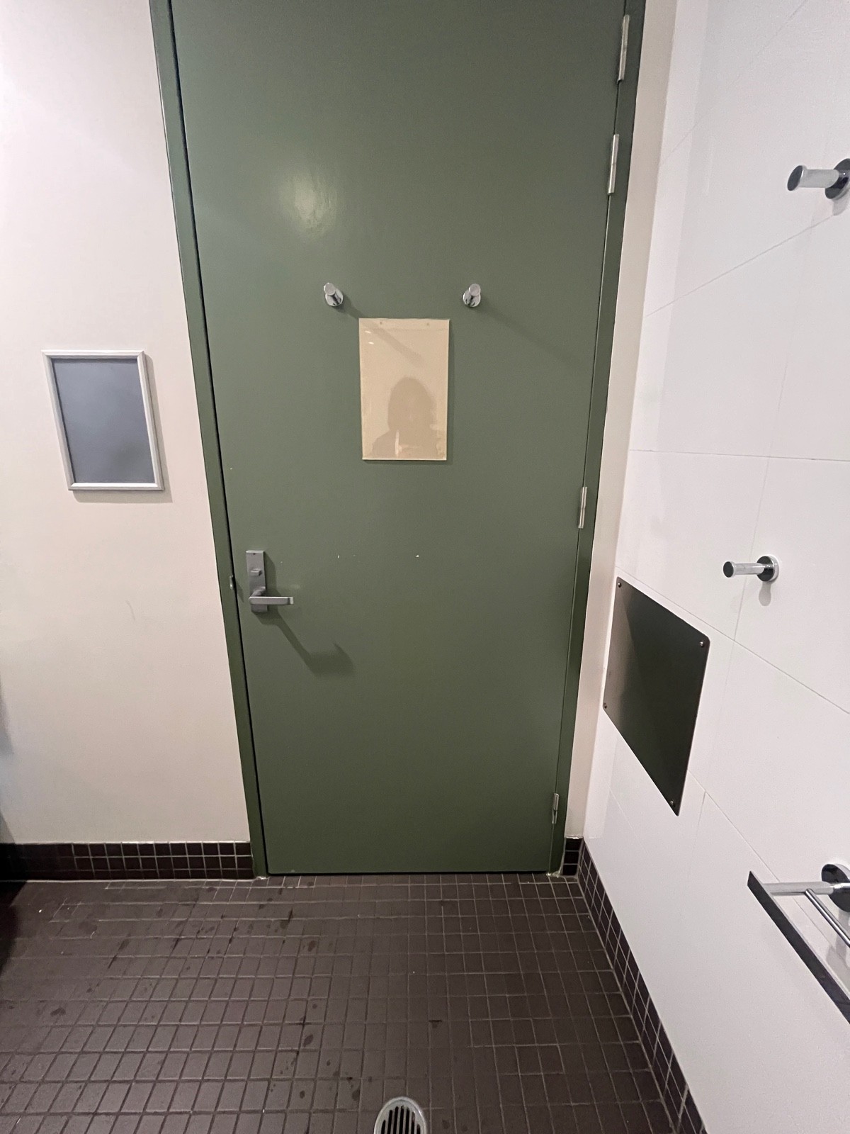 Back of door. Turn lock on left above handle. Seated height hook on right wall before door.