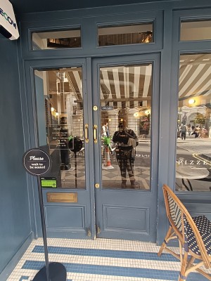 Glass doors with blue frame. Golden, metal handles in middle. Push to open.