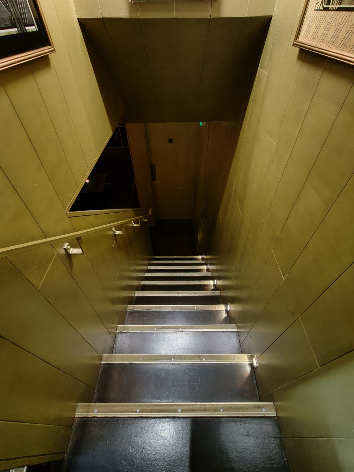 From landing facing left. Stairs going down to downstairs area and toilet. Golden handrail along left.