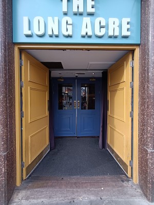 Yellow, wooden doors with golden, metal pads in middle. Push to open.