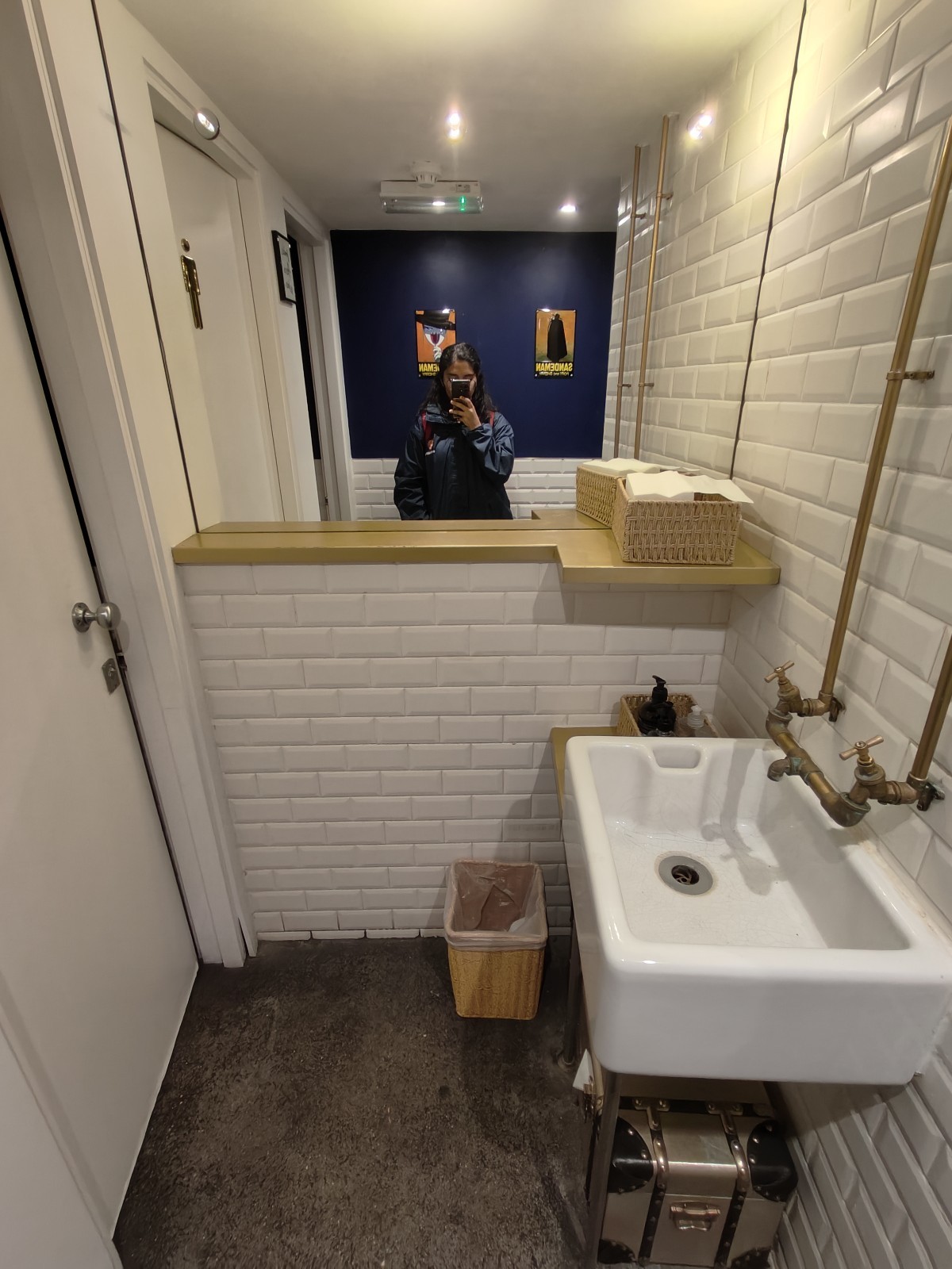 From wall facing right. Sink on right wall. Cubicles on left.