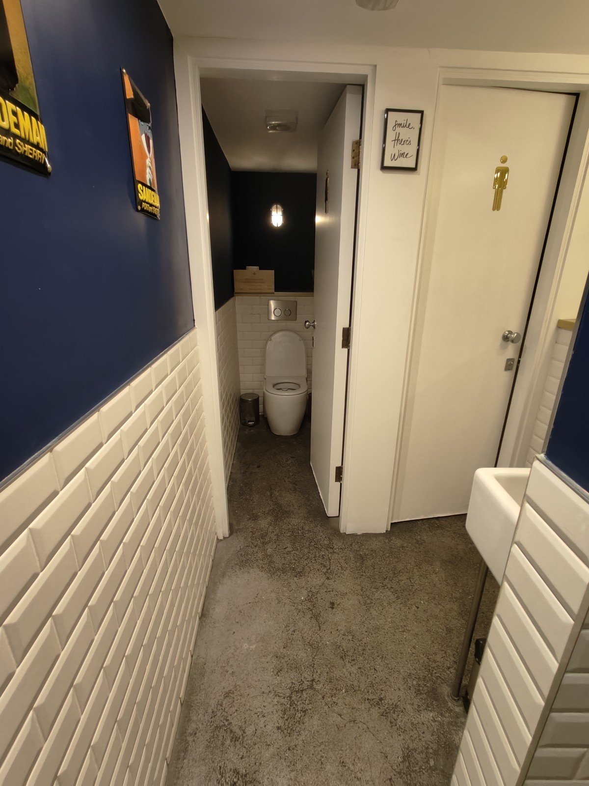 From end of path facing right. Path ahead to female toilet at back. Male toilet at back right. Wall on right.