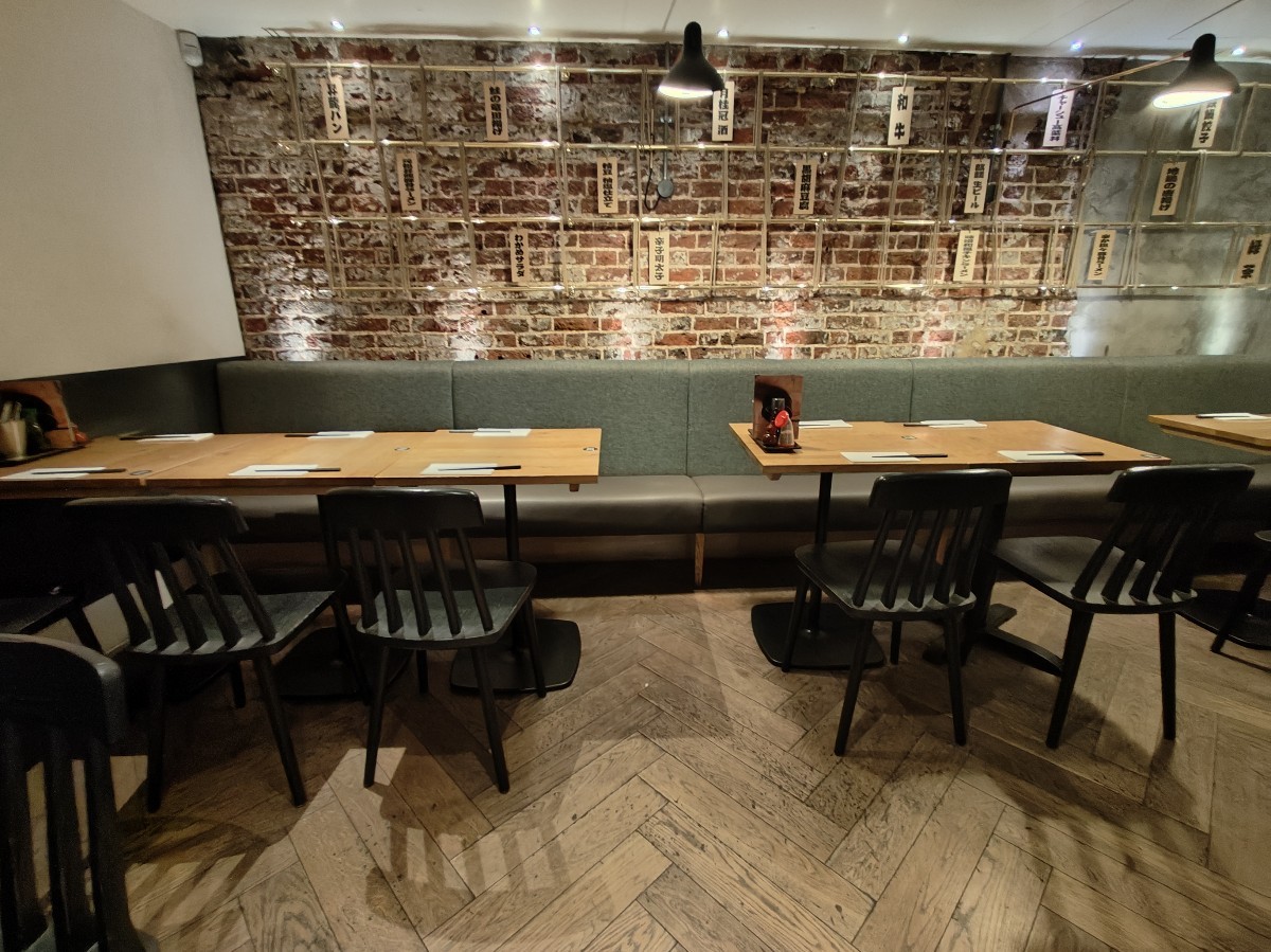 From end of tables and chairs on left facing straight. Half booth along back.