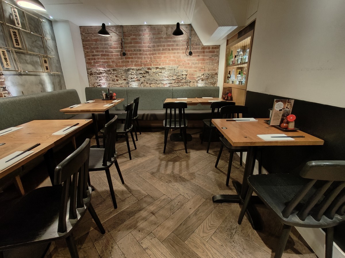 From half booth facing right. Half booths along left and back. Table and chairs on right.