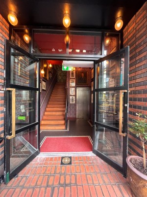 Double glass doors in black wooden frames. Pull brass handles from centre.