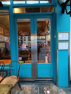 Glass door with blue frame. Silver, metal pads in middle. Push to open.