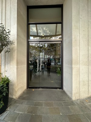 Glass doors with black frame. Silver metal handle to left of right-hand door. Push to open.