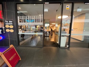 Small built in ramp leading to glass door. Push from left to open. Doormat after door.