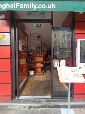 Glass door with black frame. Silver, metal pad on right. Push to open.