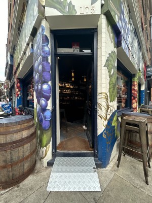 Glass door with dark blue wooden frame ahead. Gold handle on left, push to open.