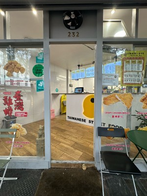 Glass door with white frame. Gold metal vertical handle on left, push to open.