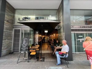 Glass double doors. Pull from middle. Outdoor front seating and parasol obstructing either side.