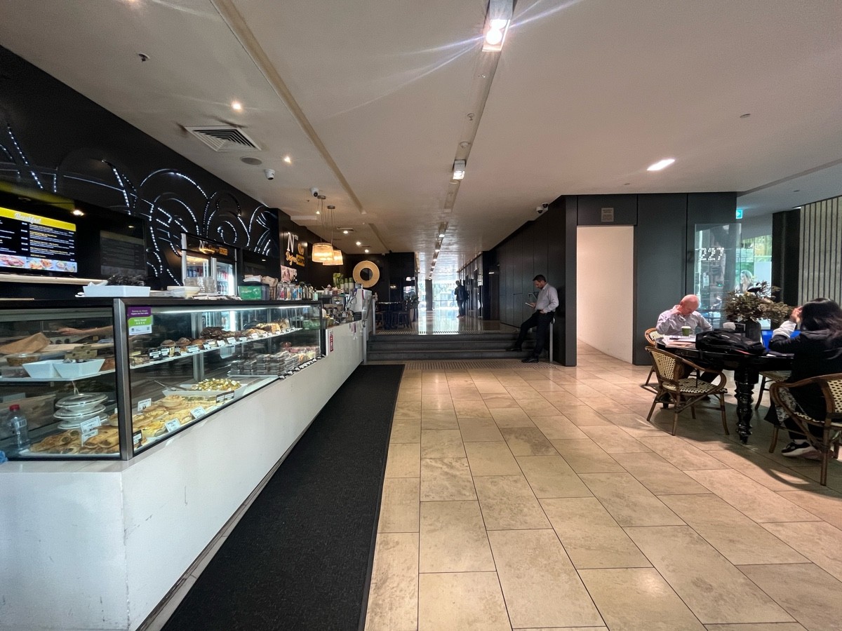 From top of ramp facing straight. Service counter along left. Steps to upstairs ahead. Archway to ramp ahead to right. Seating facing right ahead.