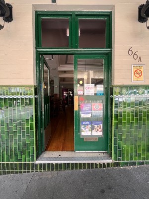 Green wooden double doors. Push from middle. One step up through doors.