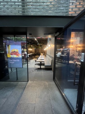 Glass door with black metal frame. Pull from black handle on left. Built in ramp down to seating directly ahead after door.