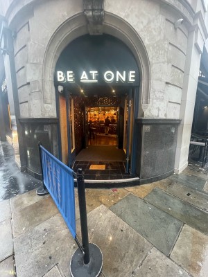 Facing venue. Restaurant banner with metal pillars ahead before main entrance.