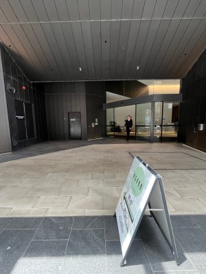 Built in ramp up from street. Signage obstructing in middle. Doors on wall ahead to right.