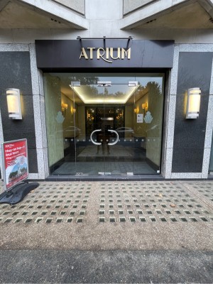 Glass doors ahead. One step up before door. Push curved silver handles at centre to open.