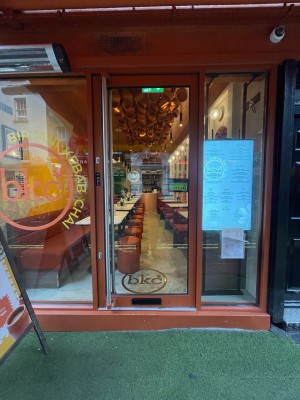 Glass door with wooden frame ahead. Silver vertical handle to left. Pull to open.