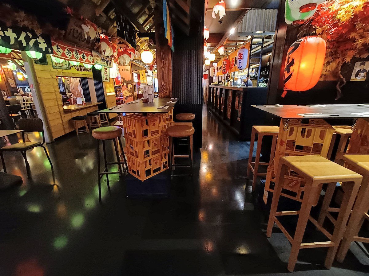 From after high tables and stools, looking right. Tables and chairs on left. High tables and stools at back. Service counter along back right.