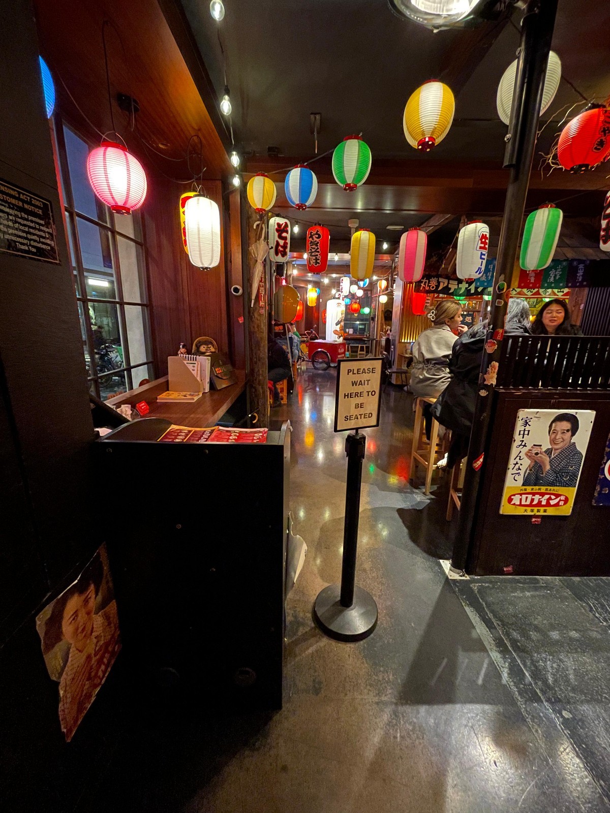 From doorway, looking straight. Host desk on left. Path to seating on right.