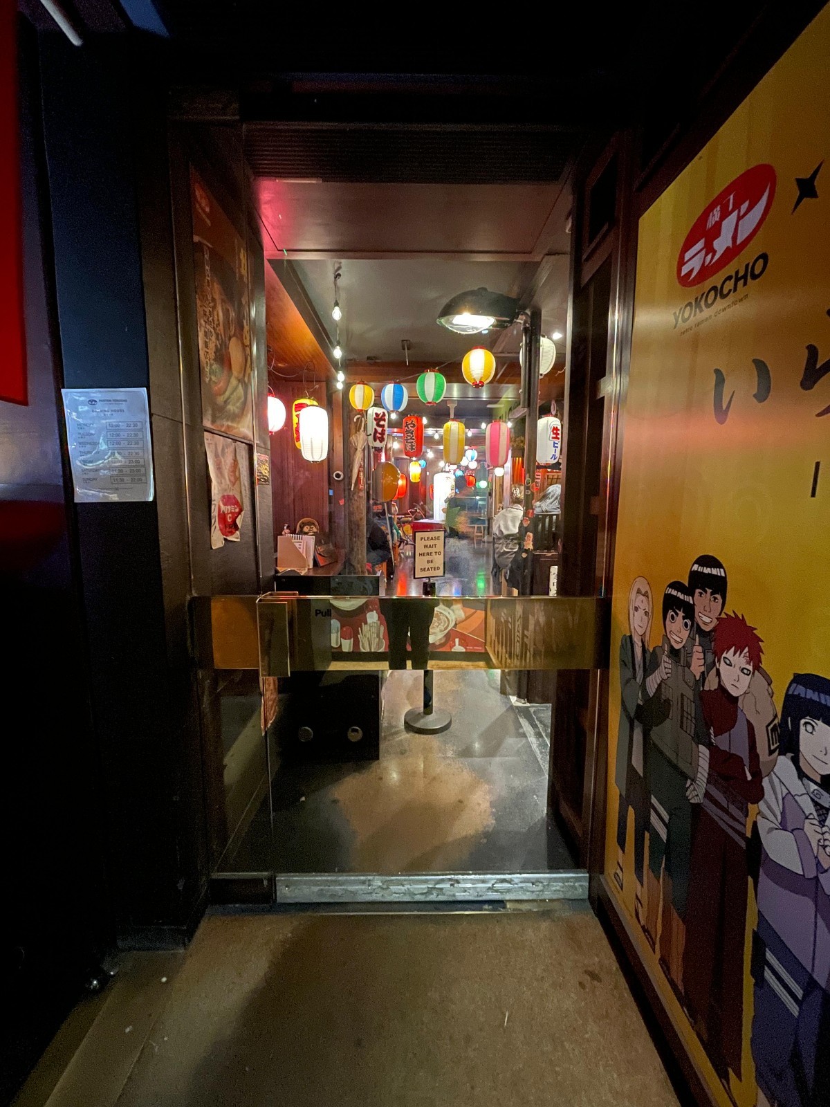 From doorway, looking left. Glass door ahead. Golden, metal handle on left. Pull to open.
