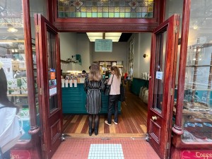 Glass double doors with red wooden panels fold open from middle.