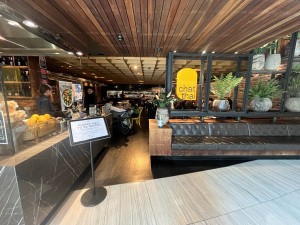 Open archway to main area. Signage obstructing on left. Waiting bench to right.