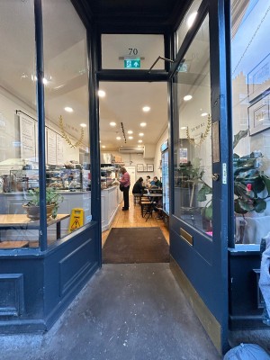 Single glass door with dark grey frame. Gold metal handle on left, pull to open.