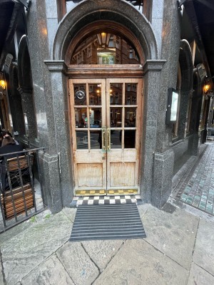 Glass and wooden light brown doors ahead. Gold metal handles to centre. Pull to open.