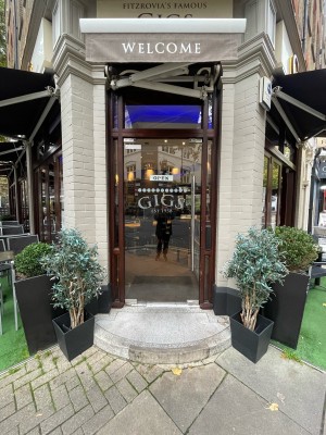Glass door with brown wooden frame ahead. Silver vertical metal handle to right. Push to open.