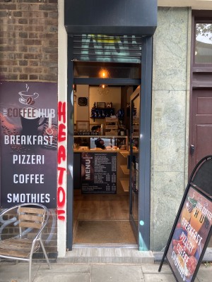 Single glass door with grey frame ahead. Push to open via metal handle on left.