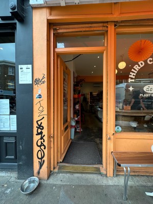 Orange and glass panelled door. Gold metal vertical handle on right, push to open.