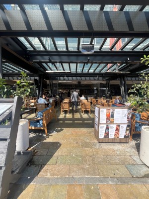 Open archway to venue. Path through outdoor front seating ahead.