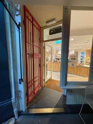 Red metal gate. Push on right to open.