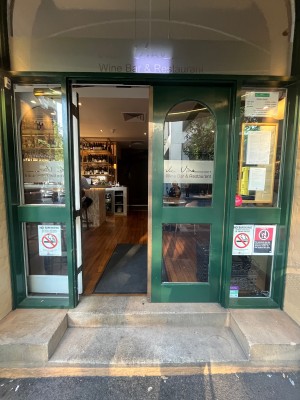 Glass double doors with green wooden frame. Push from middle.