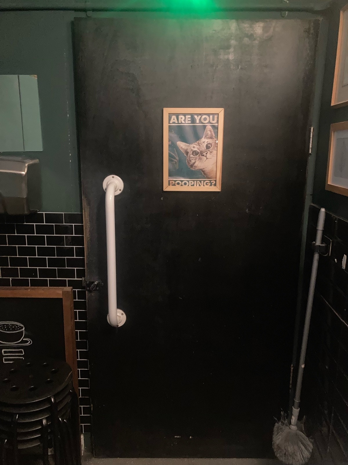 Back of door ahead. Pull to open via vertical white handrail on left.