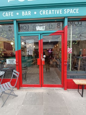 Glass doors with red frame. Push, red metal handles in middle to open.