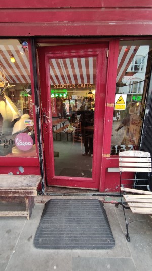 From sidewalk facing venue. Built in ramp ahead before door.