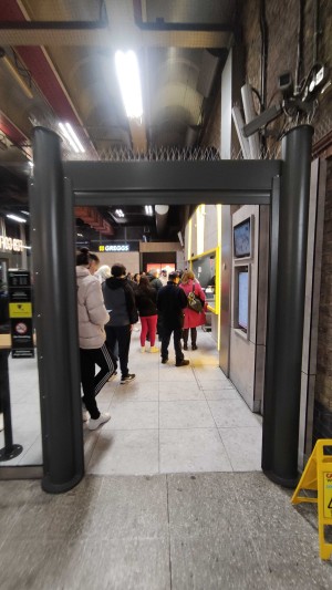 From path, facing venue. Black, metal archway ahead.