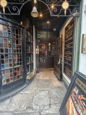 From street, facing venue. A-frame board on right. Doorway at back.