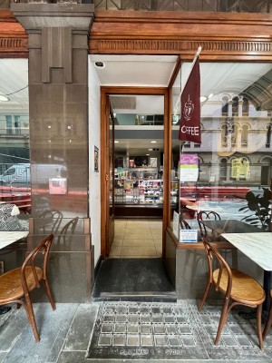 Glass door with brown wooden frame. Push from right.