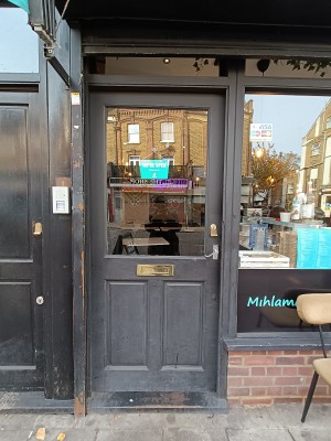Glass door with black frame. Silver, metal handle on right. Push to open.