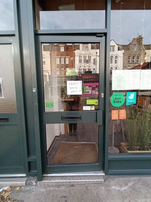 Glass door with black frame. Black, metal handle on right. Push to open.