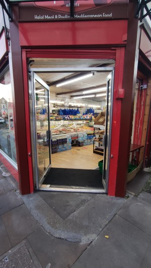 Built in ramp to glass doors with white frames. Push white handles in centre to push.