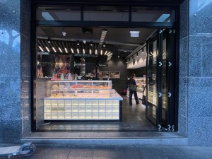 Glass doors with black frame fold open to right.