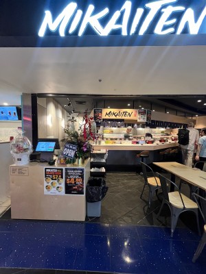 Open archway to venue past reception desk on left, and outdoor front seating on right. Bin obstructing on left next to desk.