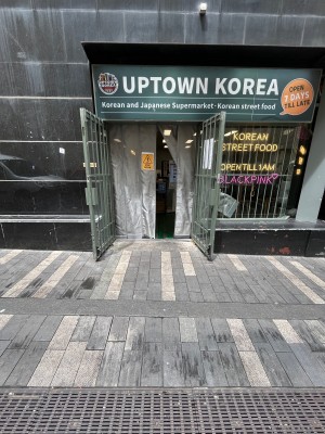 Grey metal gates followed by grey curtains. Pull gates open from grey handles in middle. Draw curtains open from middle. Doors open in business hours.