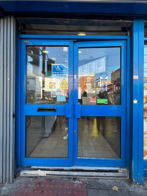 Blue framed glass doors with blue handles in middle. Push to open.